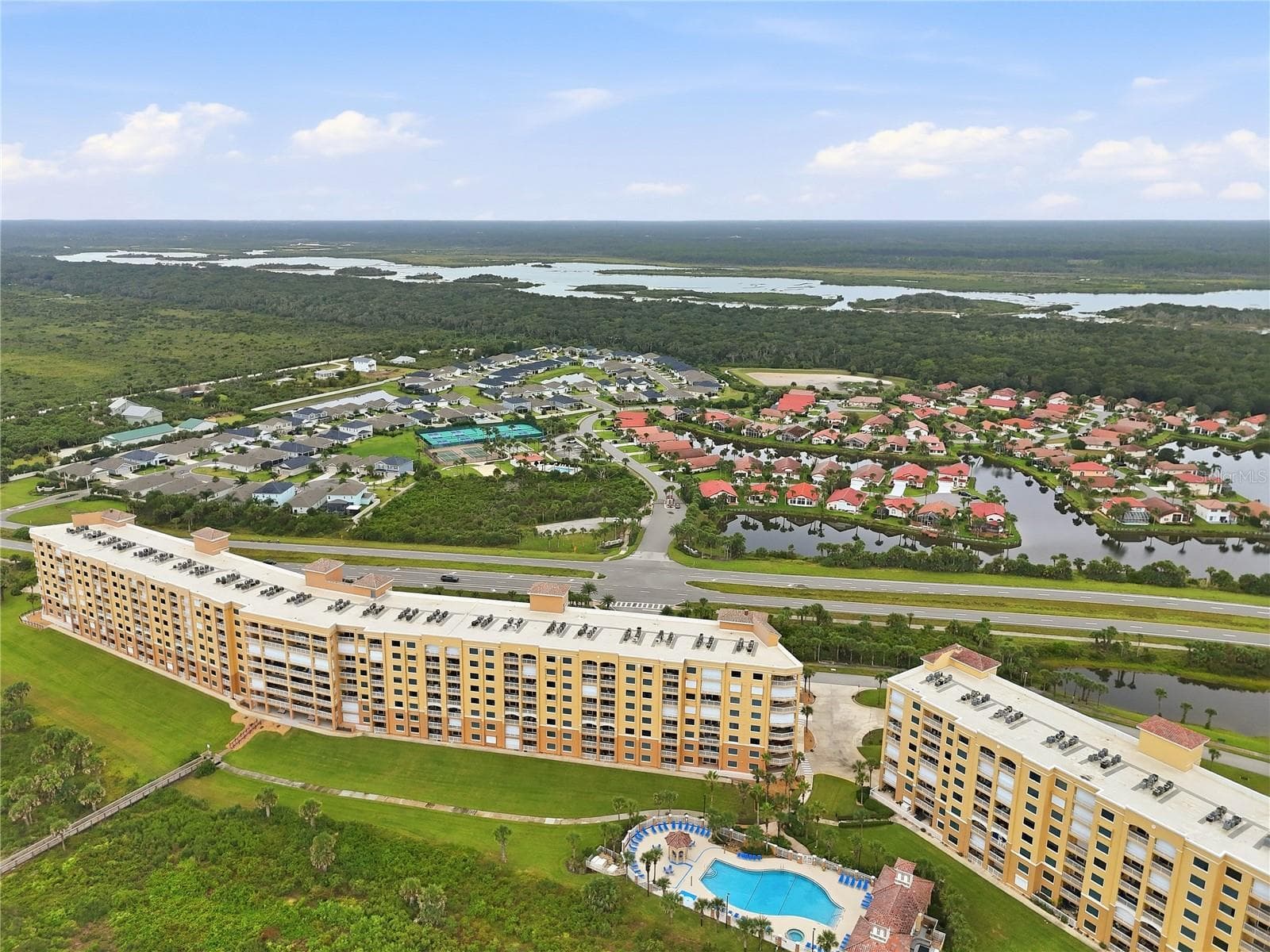 Resort amenities from the air — courts, pool, and the intracoastal beyond. - 80 SURFVIEW DR #524, PALM COAST