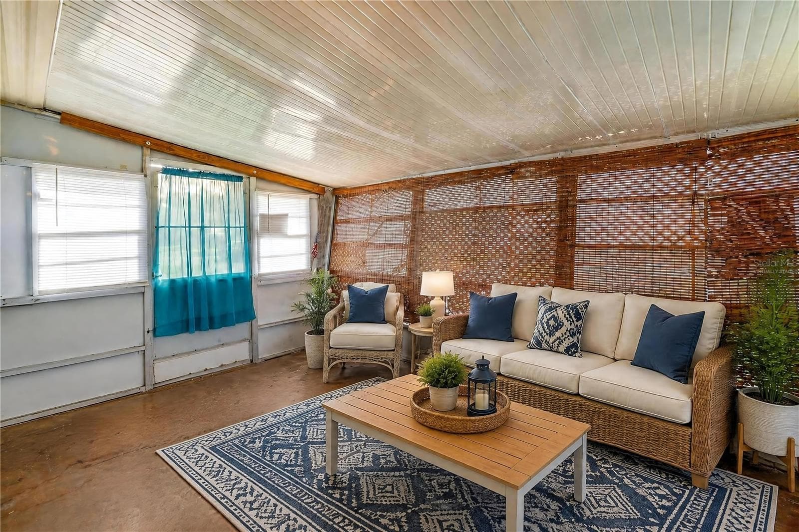 Virtually Staged - Expansive enclosed porch offers a flexible bonus space with numerous windows and woven shades for filtered natural light. - 128 KON TIKI TER, PORT ORANGE