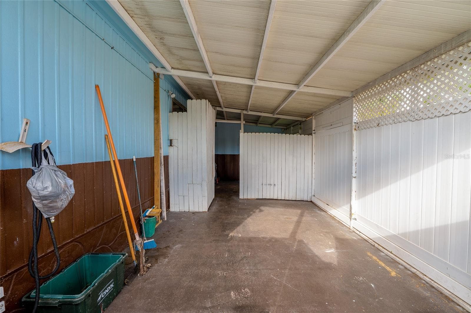 Extended carport area offers ample sheltered space with privacy panels and convenient access to the home. - 128 KON TIKI TER, PORT ORANGE