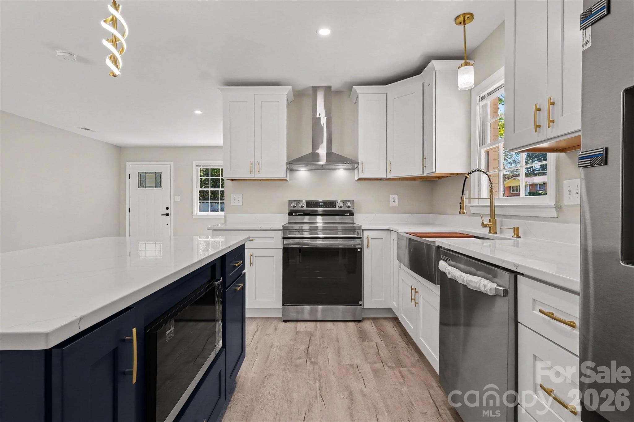 Kitchen Detail Sleek white quartz countertops paired with a new range hood - 3801 Hillock Court, Charlotte