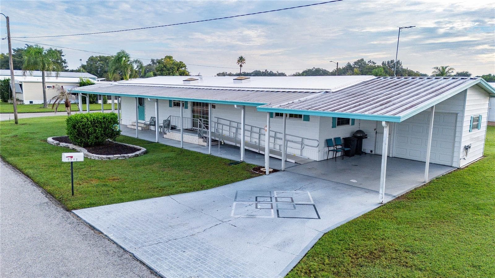Wide carport with painted driveway. - 5352 PLANT ST, ZEPHYRHILLS