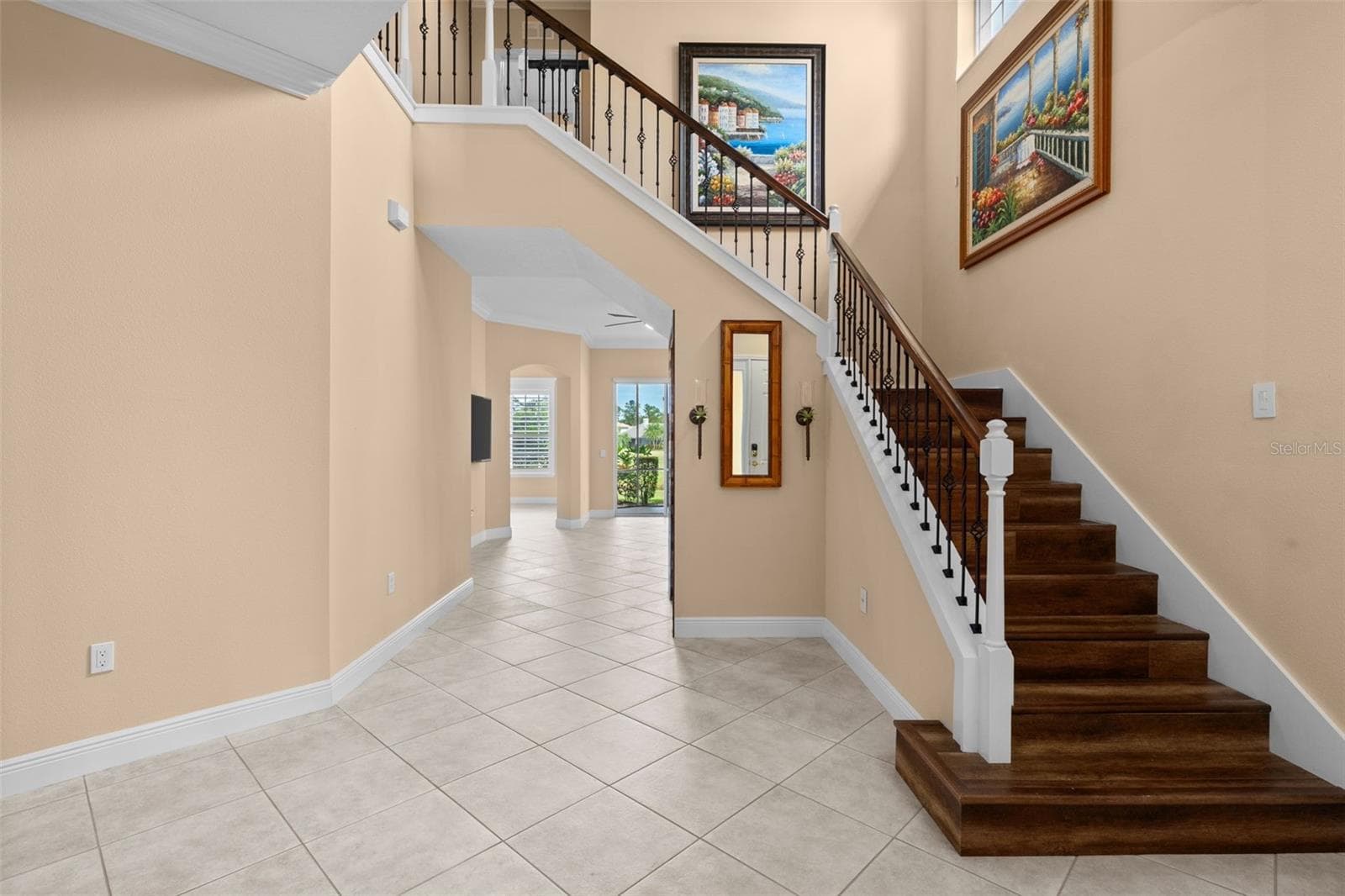Soaring ceilings and a wood staircase with wrought iron accents make a memorable first impression. - 8432 MIRAMAR WAY, LAKEWOOD RANCH