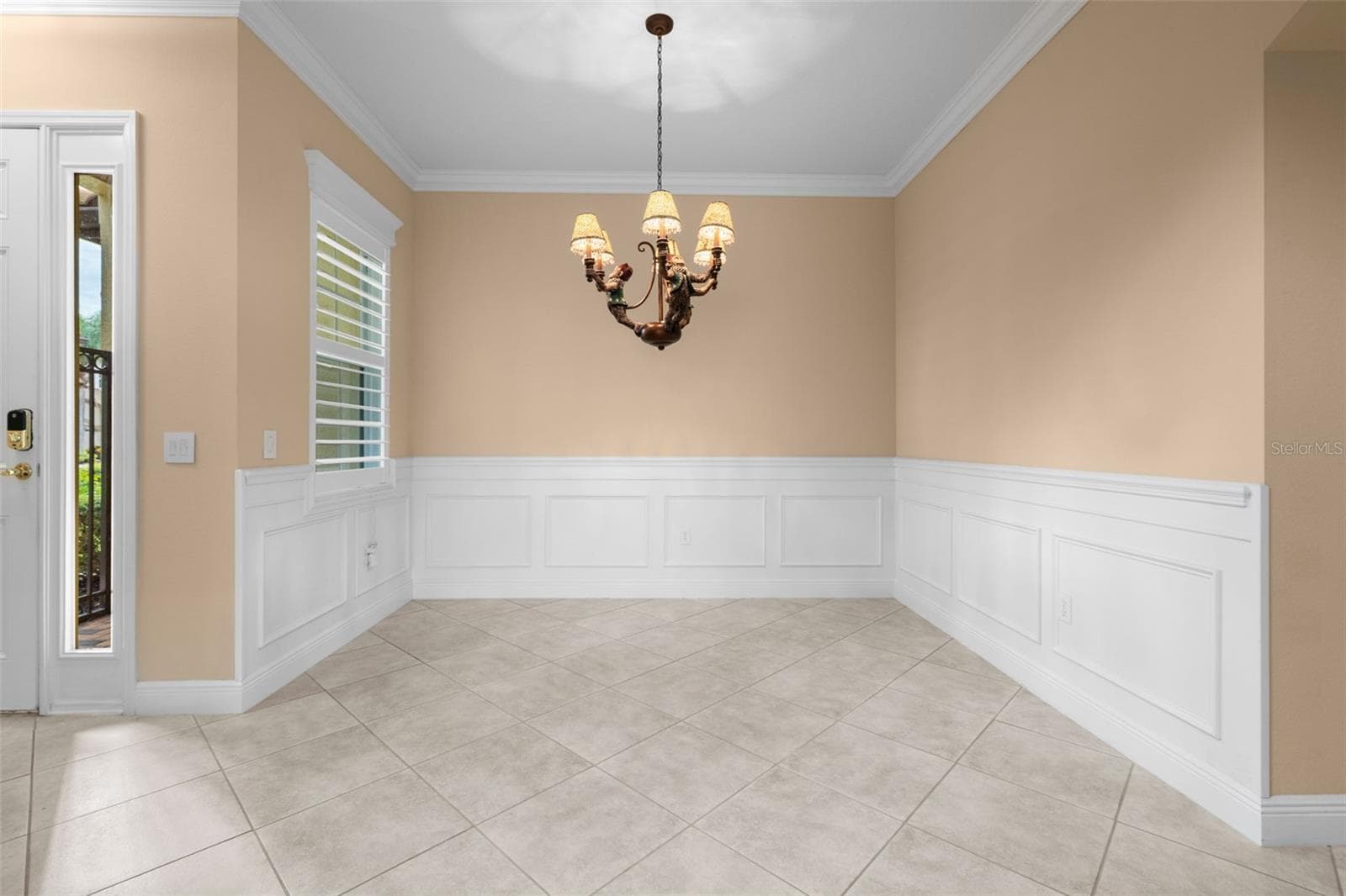 Classic wainscoting and crown molding create a lovely setting for dinners with family and friends. - 8432 MIRAMAR WAY, LAKEWOOD RANCH