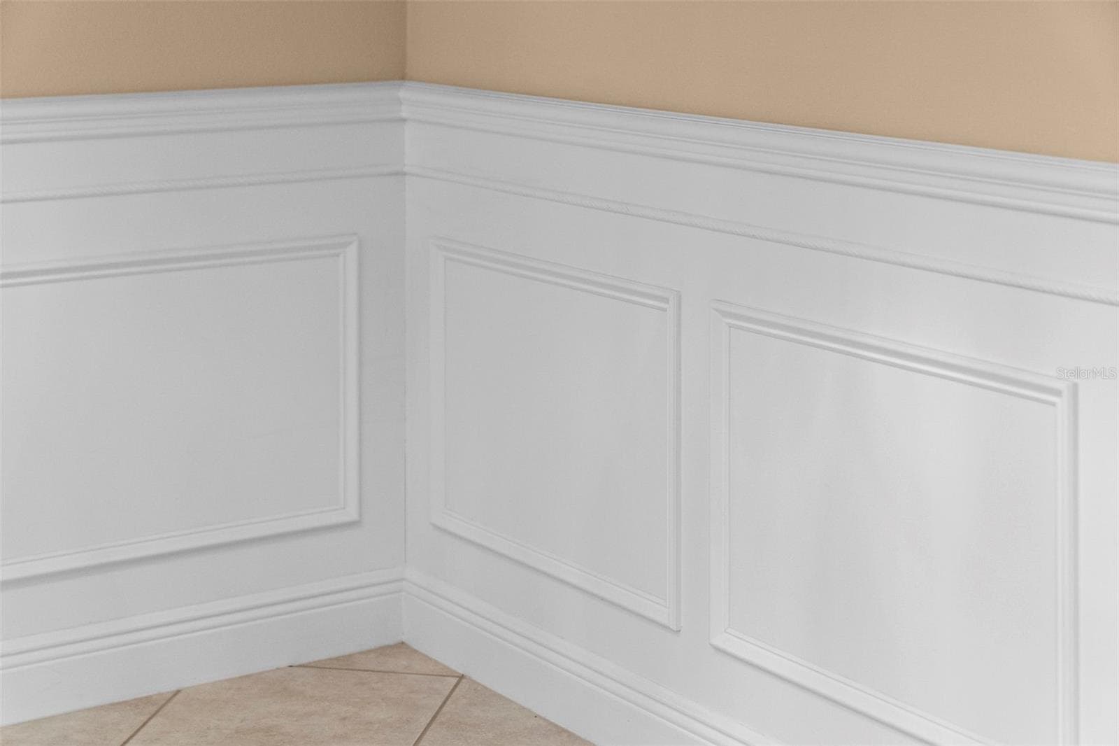 Detailed wainscoting adds timeless charm to the home’s gathering spaces. - 8432 MIRAMAR WAY, LAKEWOOD RANCH
