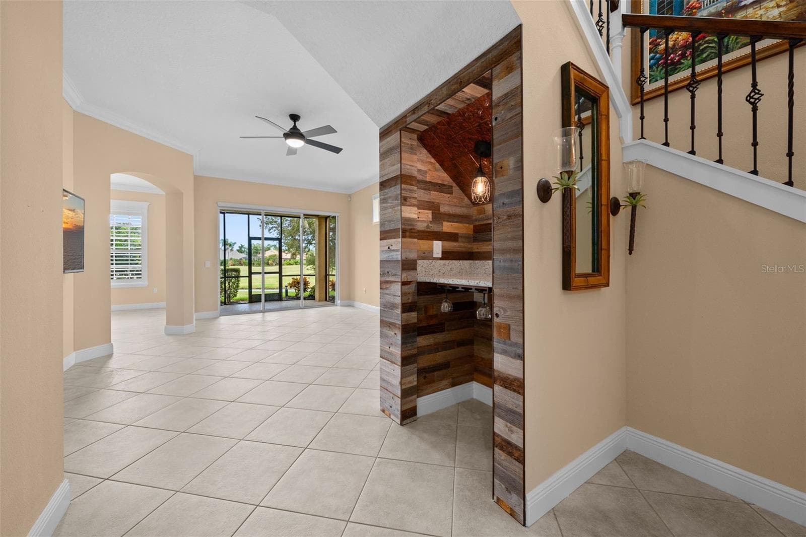 An open layout draws you toward the lanai, with a custom wine nook adding character along the way. - 8432 MIRAMAR WAY, LAKEWOOD RANCH