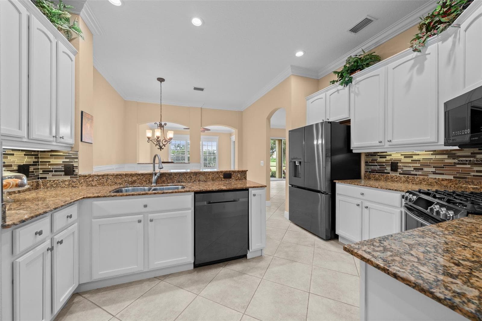 An open kitchen layout offers ample prep space while keeping you connected to family and guests. - 8432 MIRAMAR WAY, LAKEWOOD RANCH