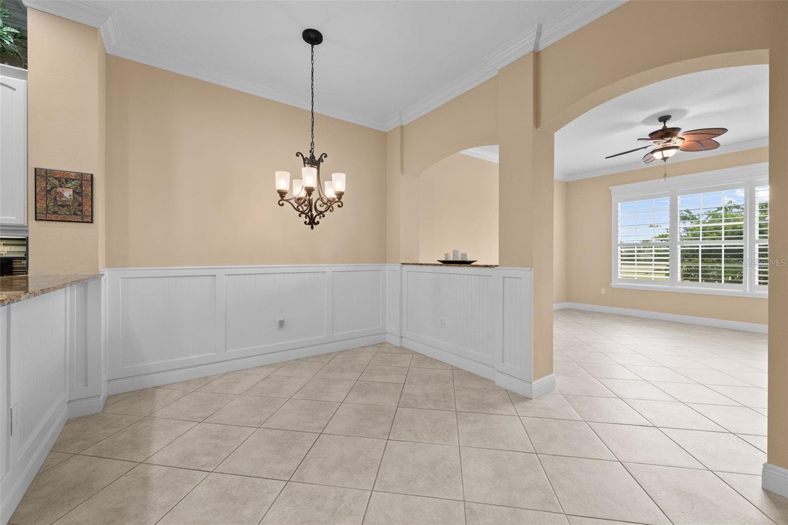 A charming spot for casual meals, framed by classic wainscoting and arched openings. - 8432 MIRAMAR WAY, LAKEWOOD RANCH