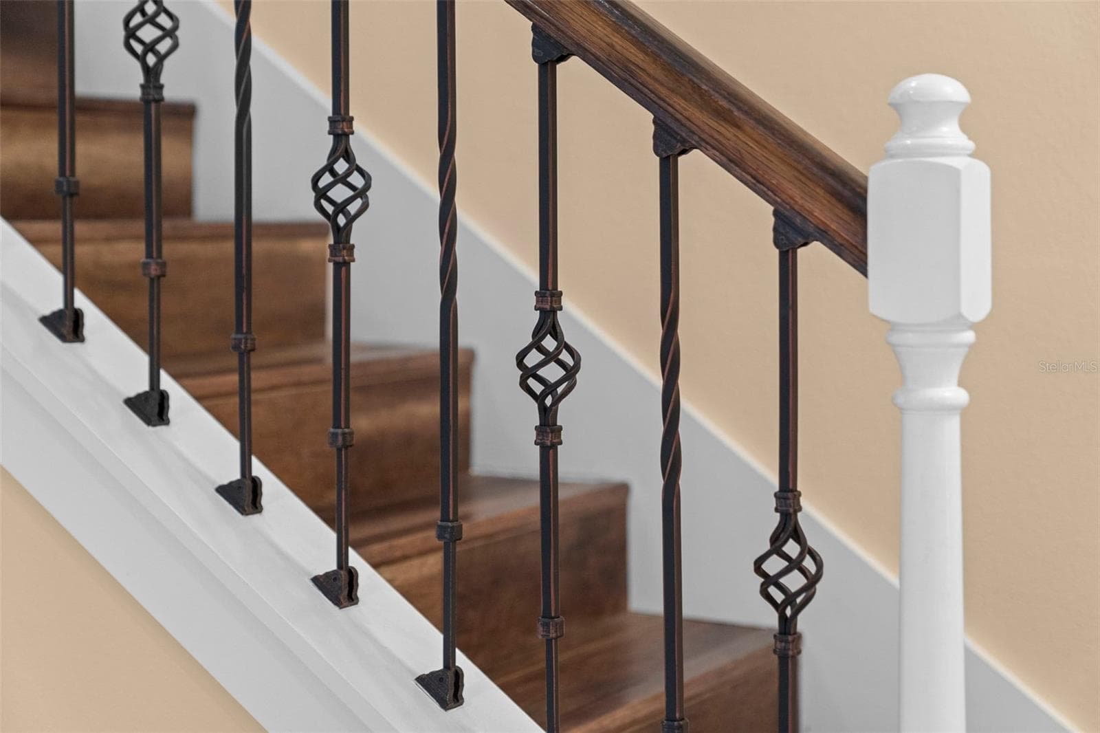 Rich wood tones and decorative ironwork add character to the staircase. - 8432 MIRAMAR WAY, LAKEWOOD RANCH