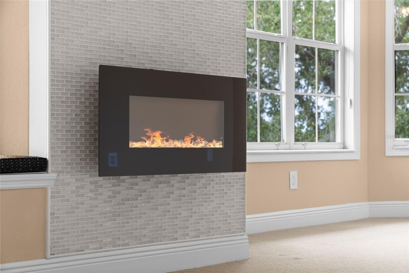 A fireplace with a mosaic tile surround adds a cozy touch to the primary suite. - 8432 MIRAMAR WAY, LAKEWOOD RANCH