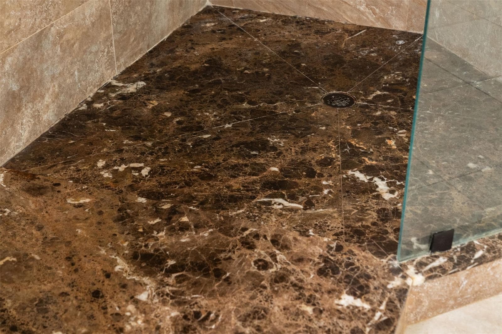 Richly patterned stone gives the walk-in shower a distinctive finishing touch. - 8432 MIRAMAR WAY, LAKEWOOD RANCH