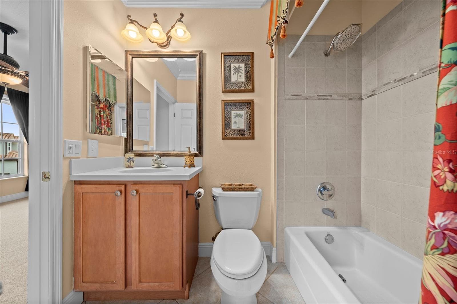 A conveniently arranged guest bath with a tub-and-shower combination and vanity storage. - 8432 MIRAMAR WAY, LAKEWOOD RANCH
