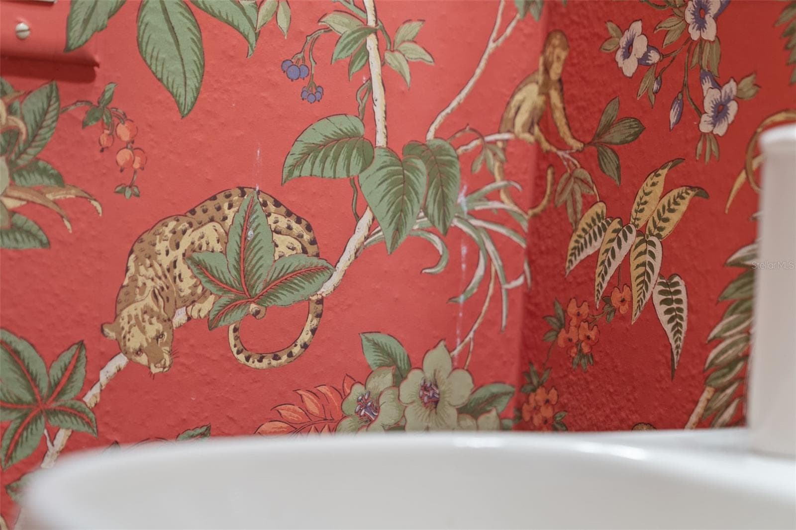 Cheerful patterned wallpaper and a classic pedestal sink bring personality to this bathroom. - 8432 MIRAMAR WAY, LAKEWOOD RANCH