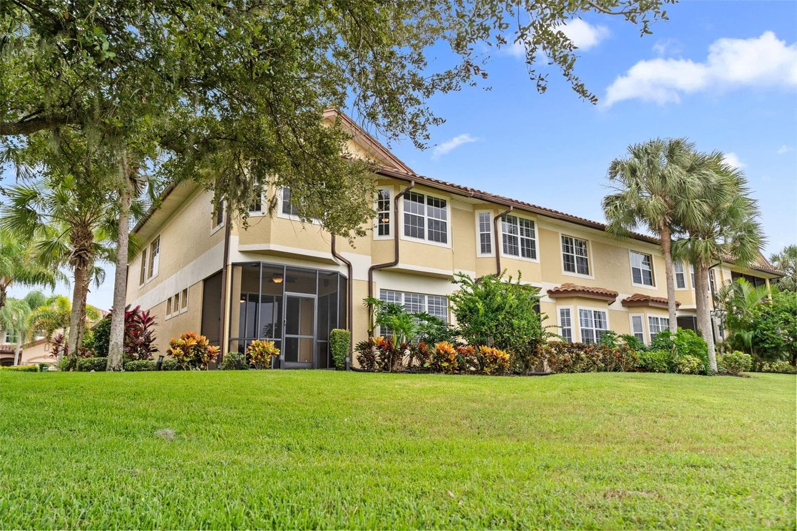 Tropical landscaping and a screened lanai create an inviting setting to enjoy the outdoors. - 8432 MIRAMAR WAY, LAKEWOOD RANCH