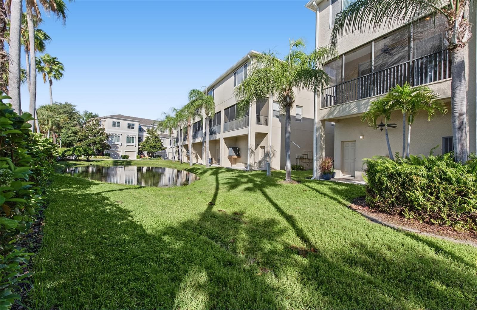 Back patio with ceiling fan and a nice retention pond where you will always see a family of ducks. - 1146 VENETIAN HARBOR DR NE, ST PETERSBURG