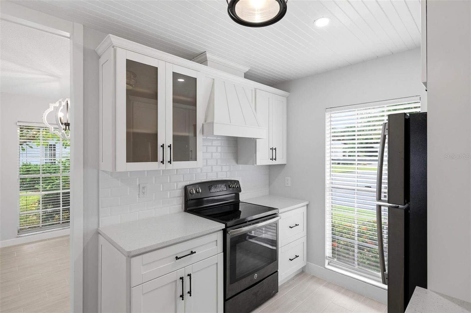 Another view of the kitchen including the stove and cabinetry. Glass door cabinet for your glassware or special dishes. - 4 ANTIGUA CIR #6, ENGLEWOOD