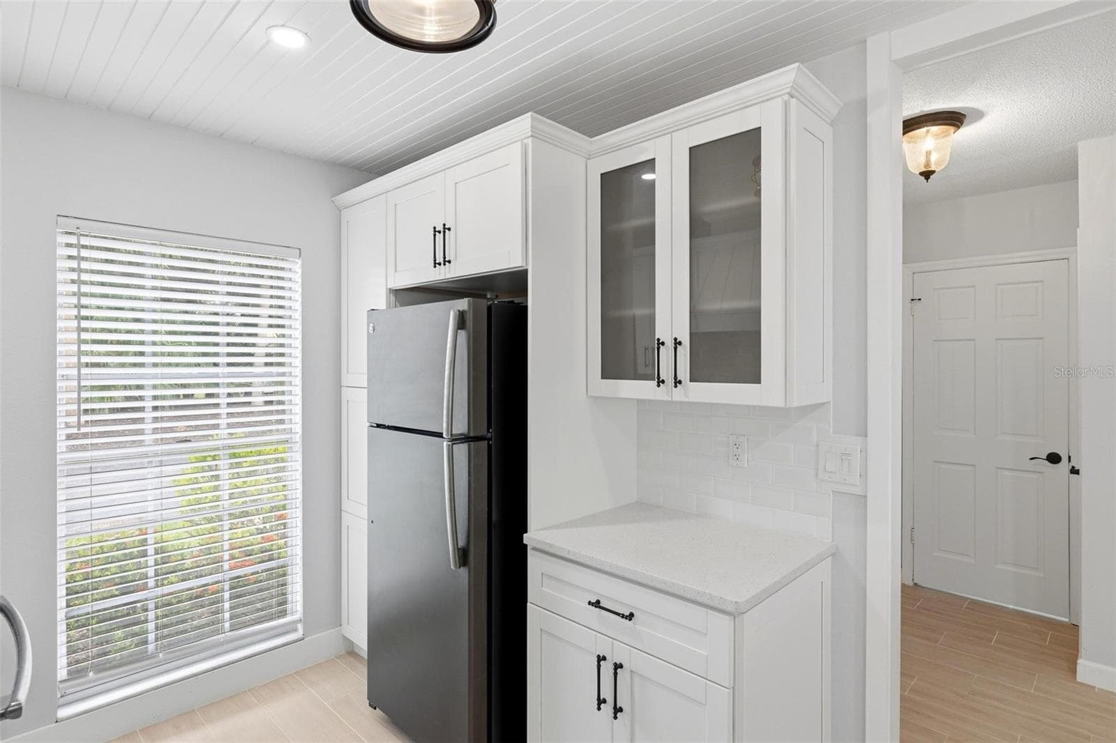 The opposite wall of the kitchen with pantry area, refrigerator and large window lending lots of natural light into the kitchen. - 4 ANTIGUA CIR #6, ENGLEWOOD
