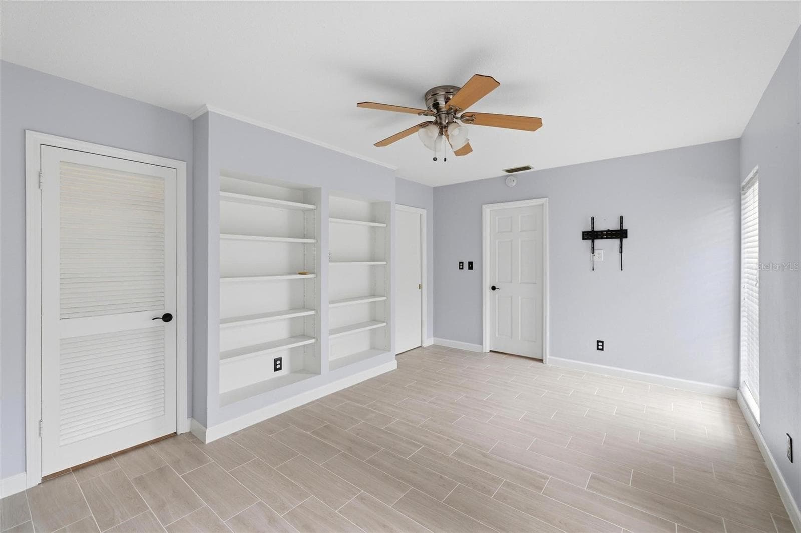 Full view of the built in shelves in the 2nd bedroom. Door to closet and door to laundry room. - 4 ANTIGUA CIR #6, ENGLEWOOD