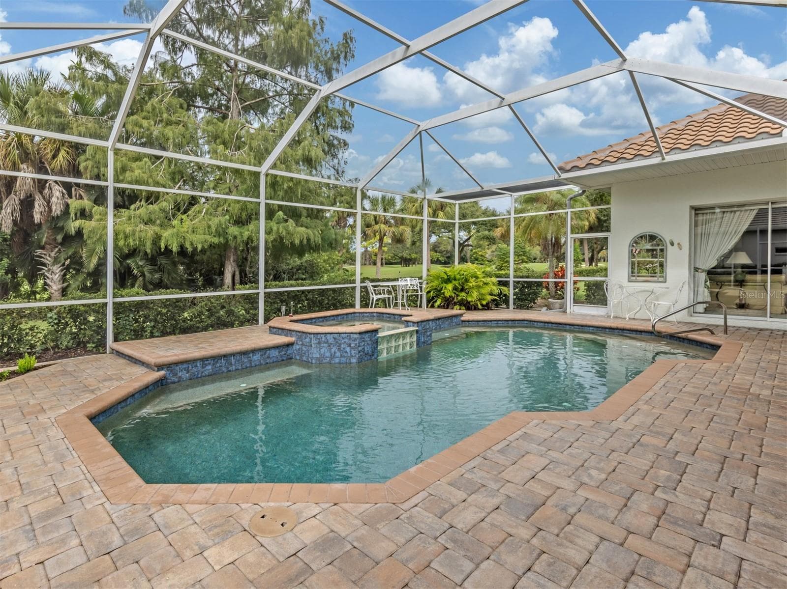Screened lanai surrounded by lush gardens, offering privacy from the fairway. - 2009 TOCOBAGA LN, NOKOMIS
