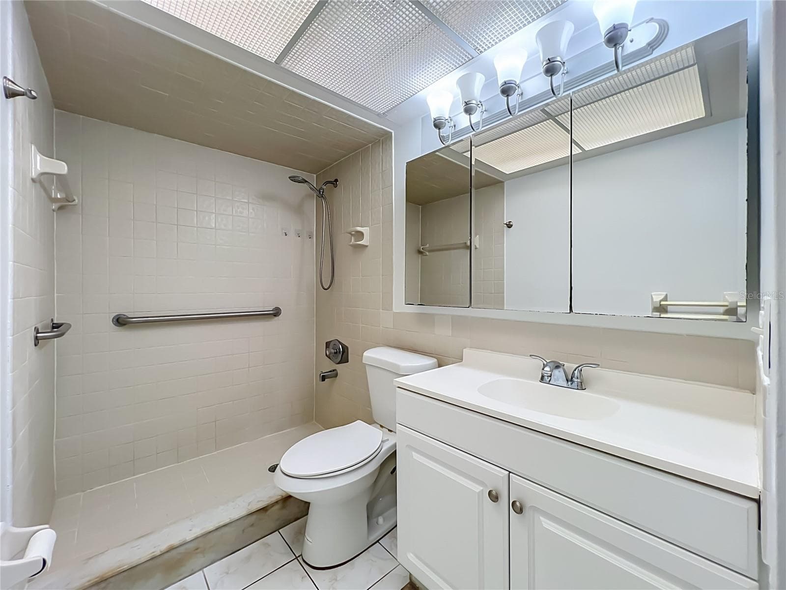 Primary bathroom with shower and generous vanity storage. - 1225 CARRIAGE LN #1, ORLANDO