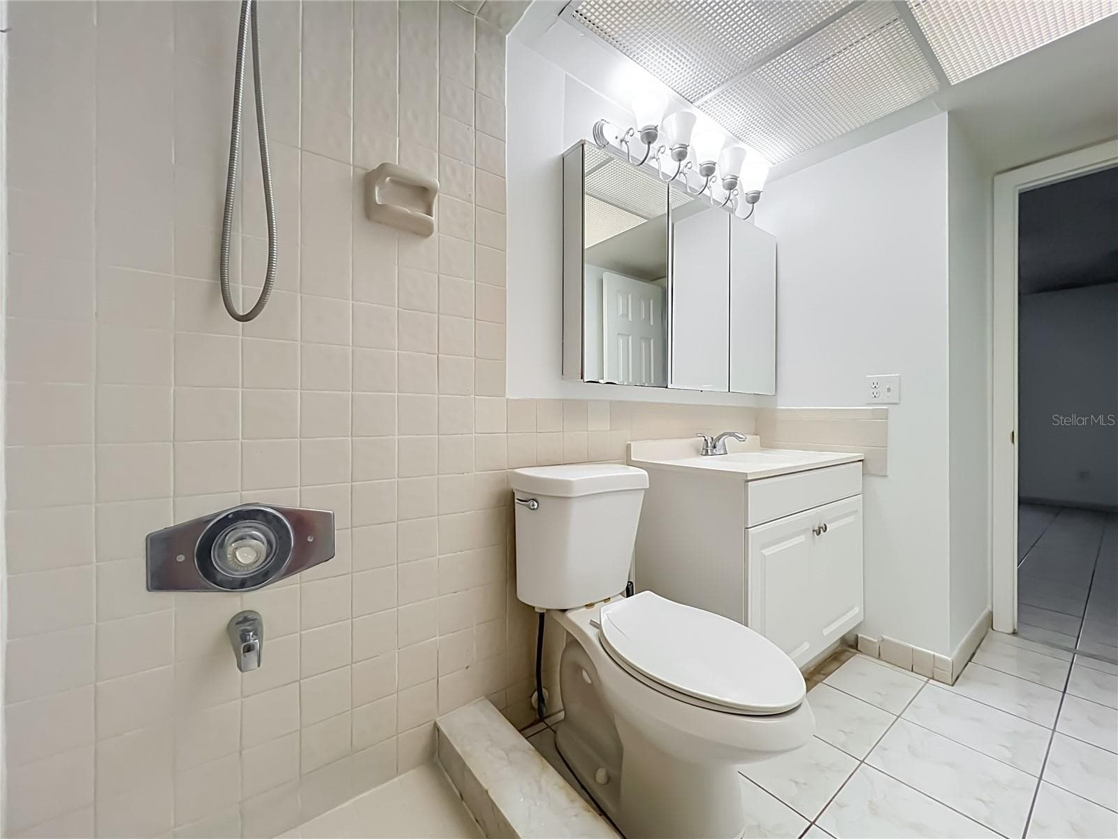 Primary bathroom features a walk-in shower with convenient grab bars. - 1225 CARRIAGE LN #1, ORLANDO