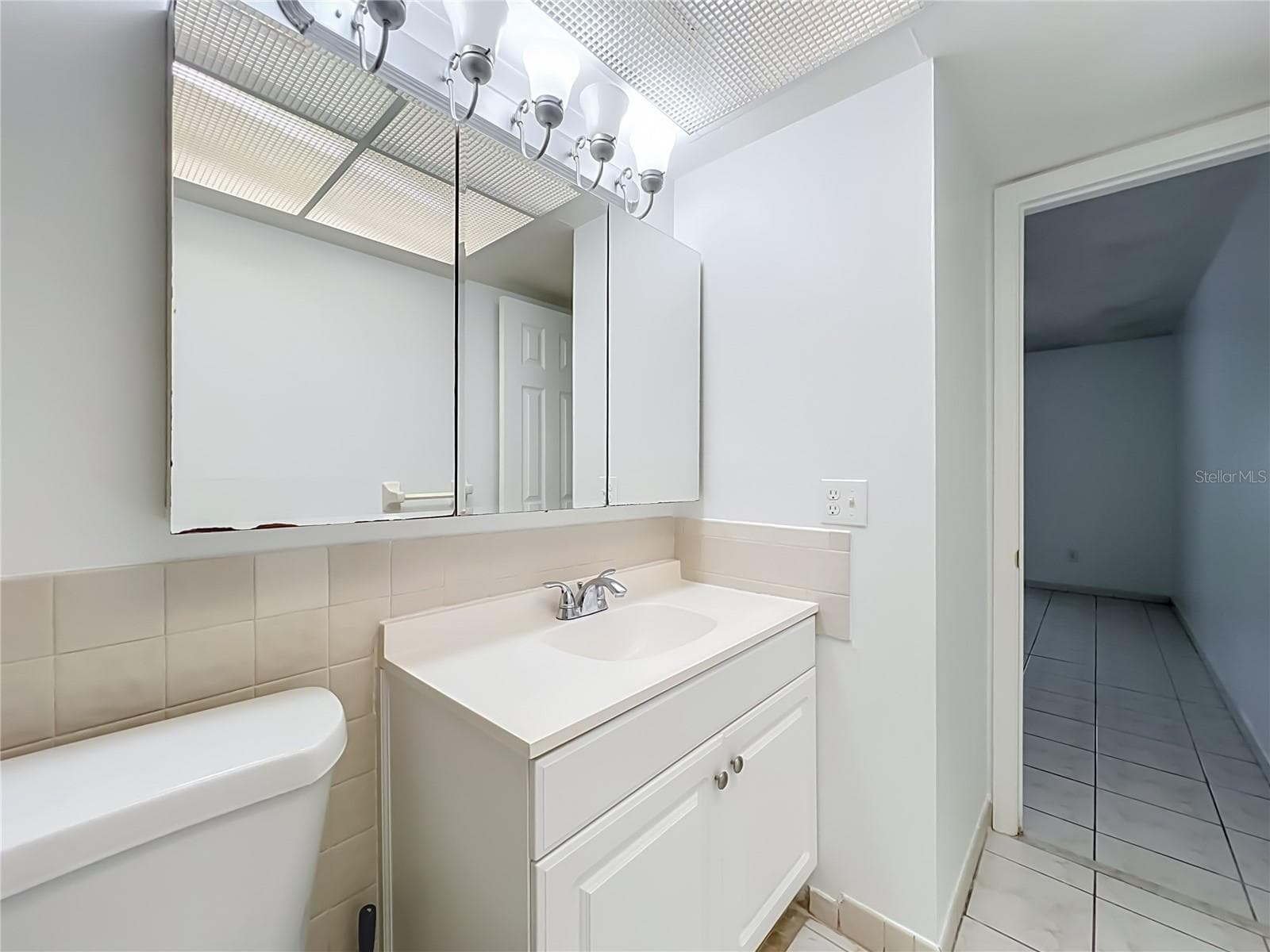 Bright vanity area with mirrored medicine cabinet and additional storage. - 1225 CARRIAGE LN #1, ORLANDO