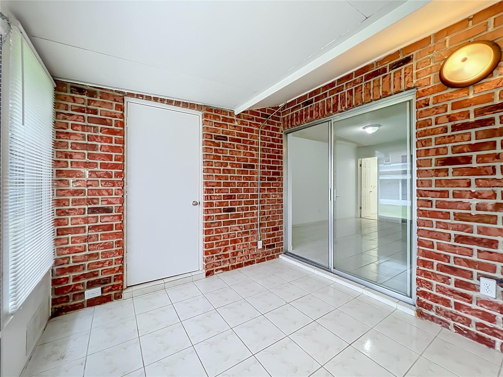 Exposed brick brings warmth and character to the spacious Florida room. - 1225 CARRIAGE LN #1, ORLANDO