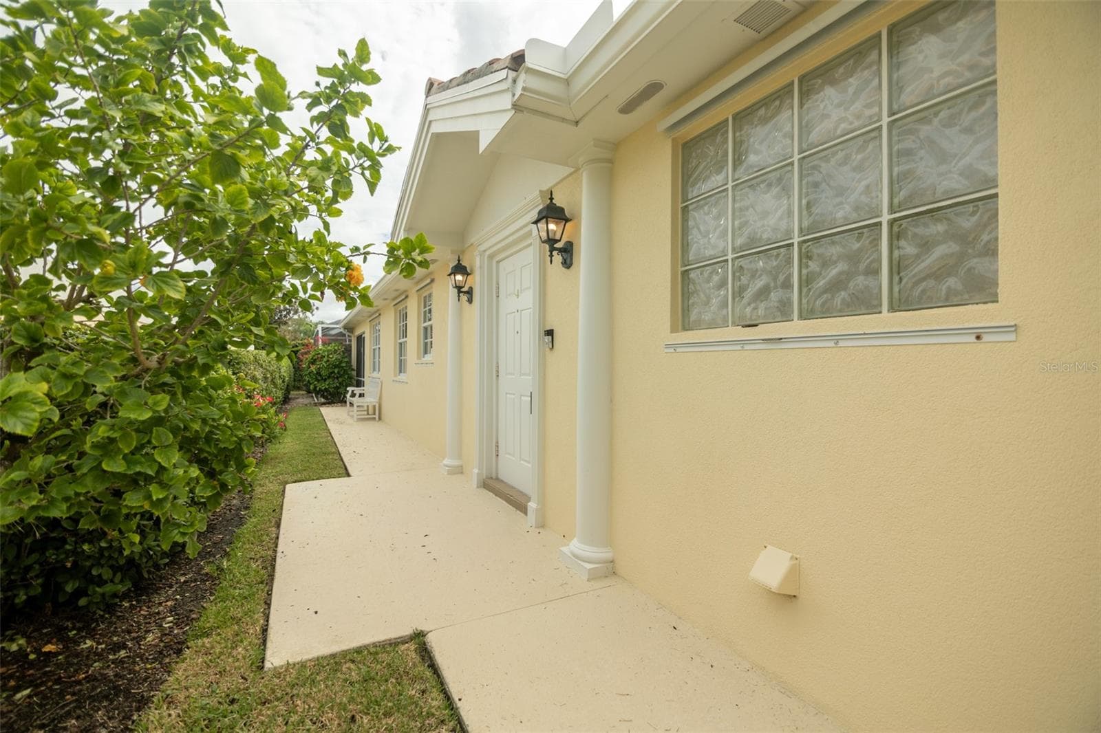 View of walk way leading to front door and beyond to the seprate pool entrance. - 8876 ESTEPONA CT, SARASOTA