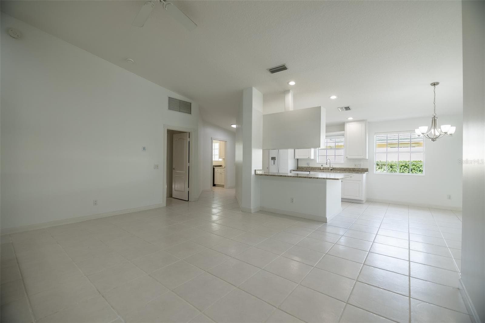 Formal living room looking towards the kitchen and entrance. - 8876 ESTEPONA CT, SARASOTA