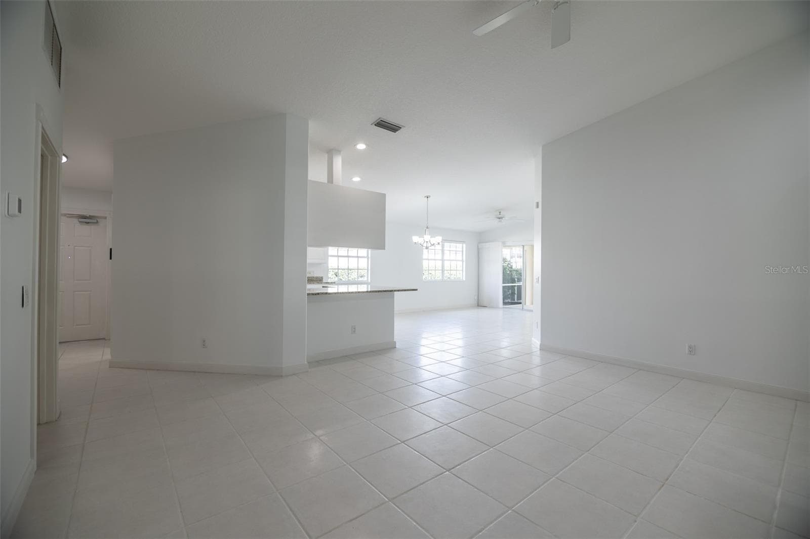 Formal living room looking towards the kitchen and entrance. - 8876 ESTEPONA CT, SARASOTA