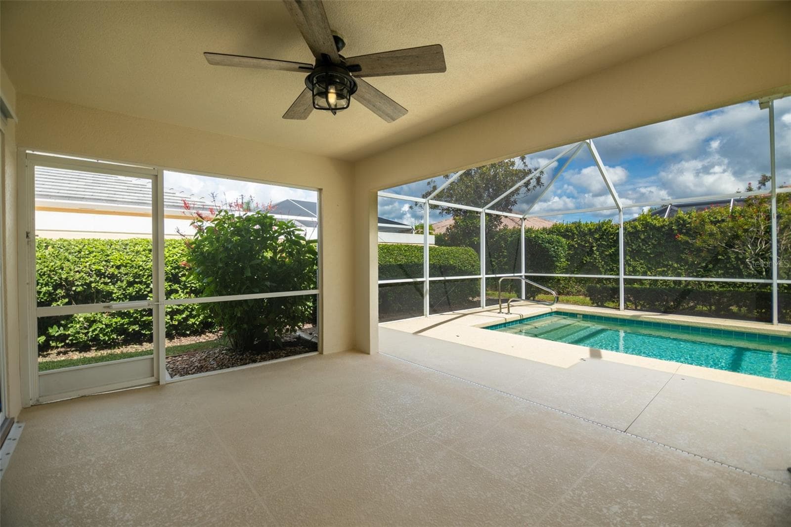 Back patio screen door on left with view of the pool on the right. - 8876 ESTEPONA CT, SARASOTA