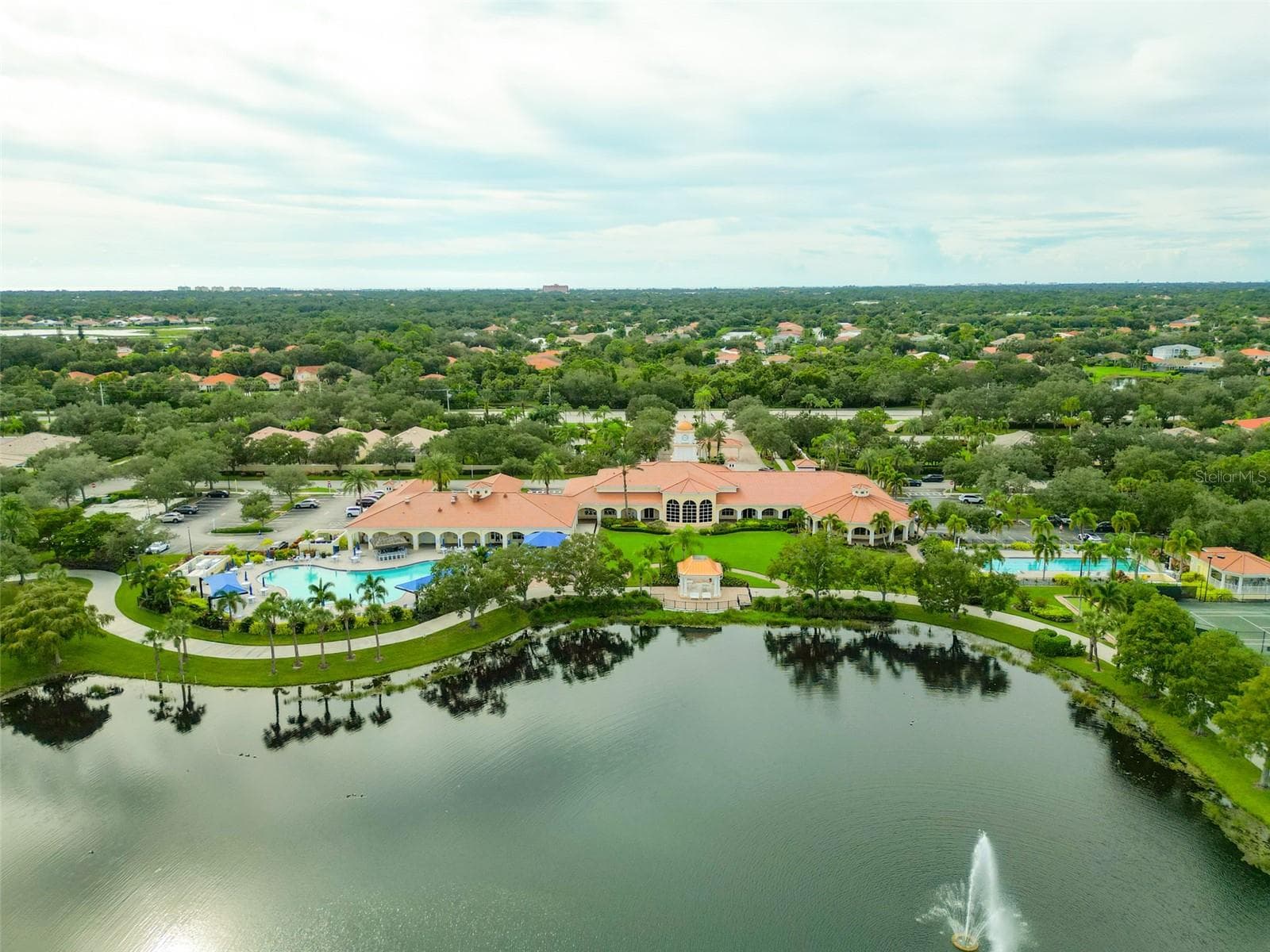 Community center with view of both a lagoon and lap pool with the community center and gazebo in the middle. - 8876 ESTEPONA CT, SARASOTA