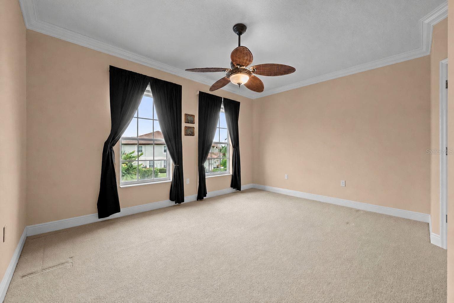 A spacious bedroom with soft natural light, crown molding, and room to make it your own-with walk-in closet - 8432 MIRAMAR WAY, LAKEWOOD RANCH