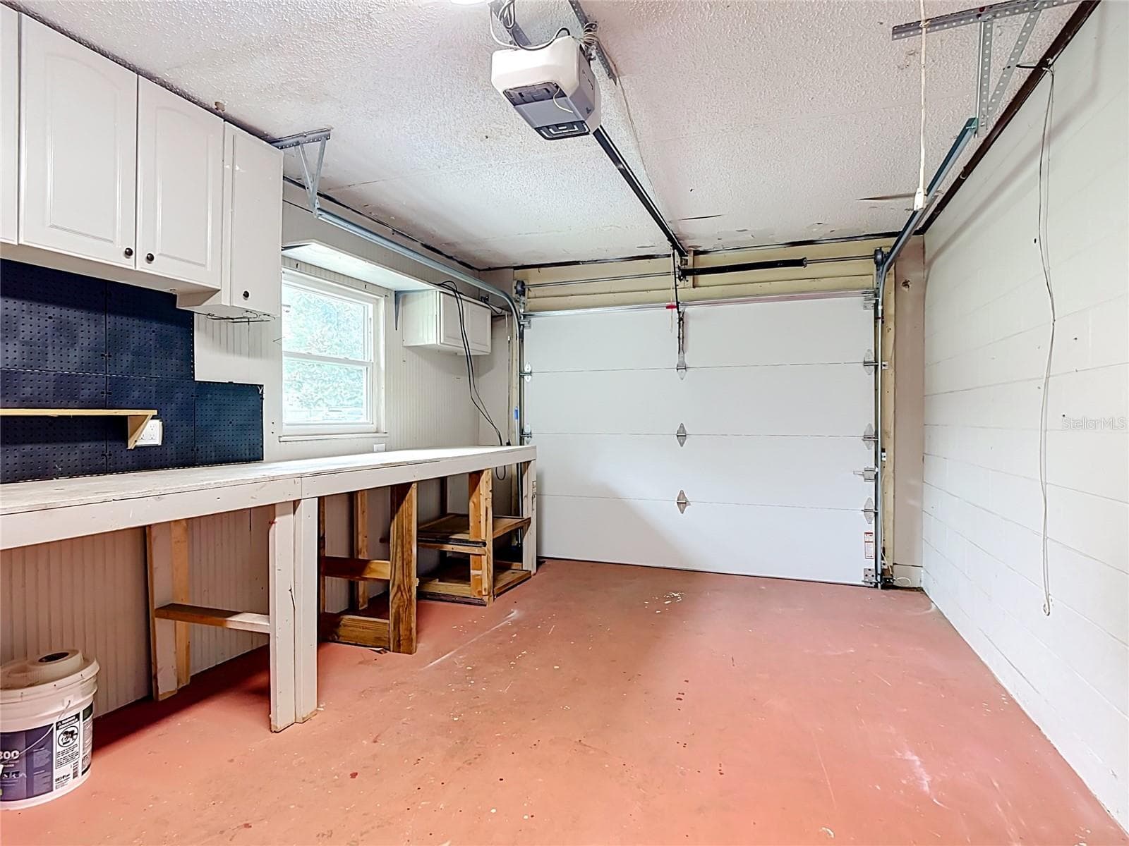 Garage with new insulatated door, custom workbench and tons of storage cabinets. - 112 10TH ST, ST CLOUD