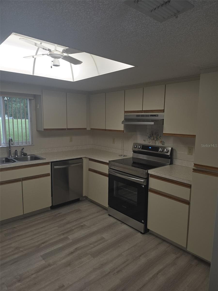 Kitchen with stainless steel appliances and skylight - 10765 SW 63RD TER, OCALA
