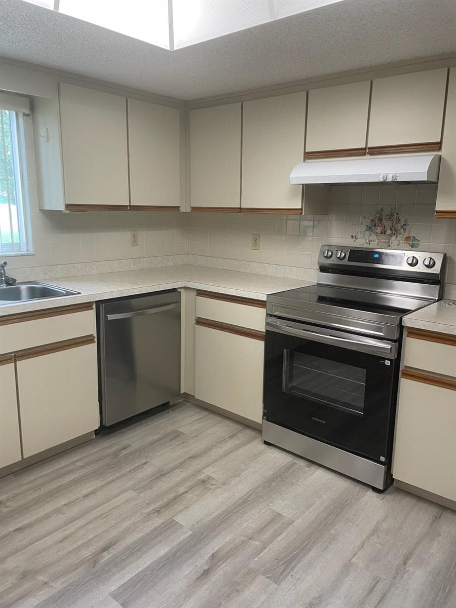 Kitchen with stainless range and dishwasher - 10765 SW 63RD TER, OCALA