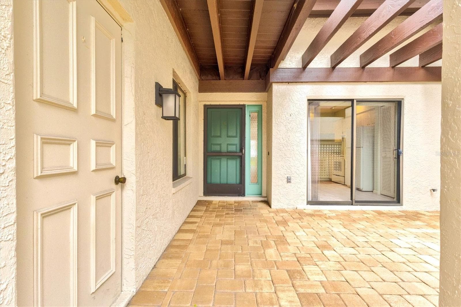 Garage door to the left, showing covered walkway to the front door - 3118 WINDRUSH BOURNE #8, SARASOTA