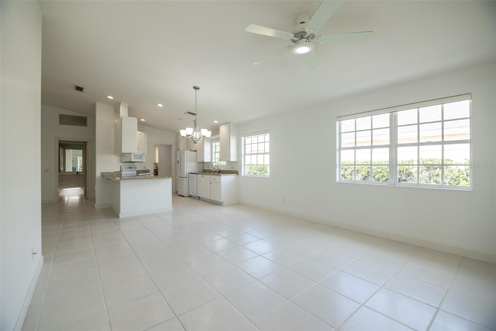 Dining and or living room with views to the kitchen and formal living room. - 8876 ESTEPONA CT, SARASOTA