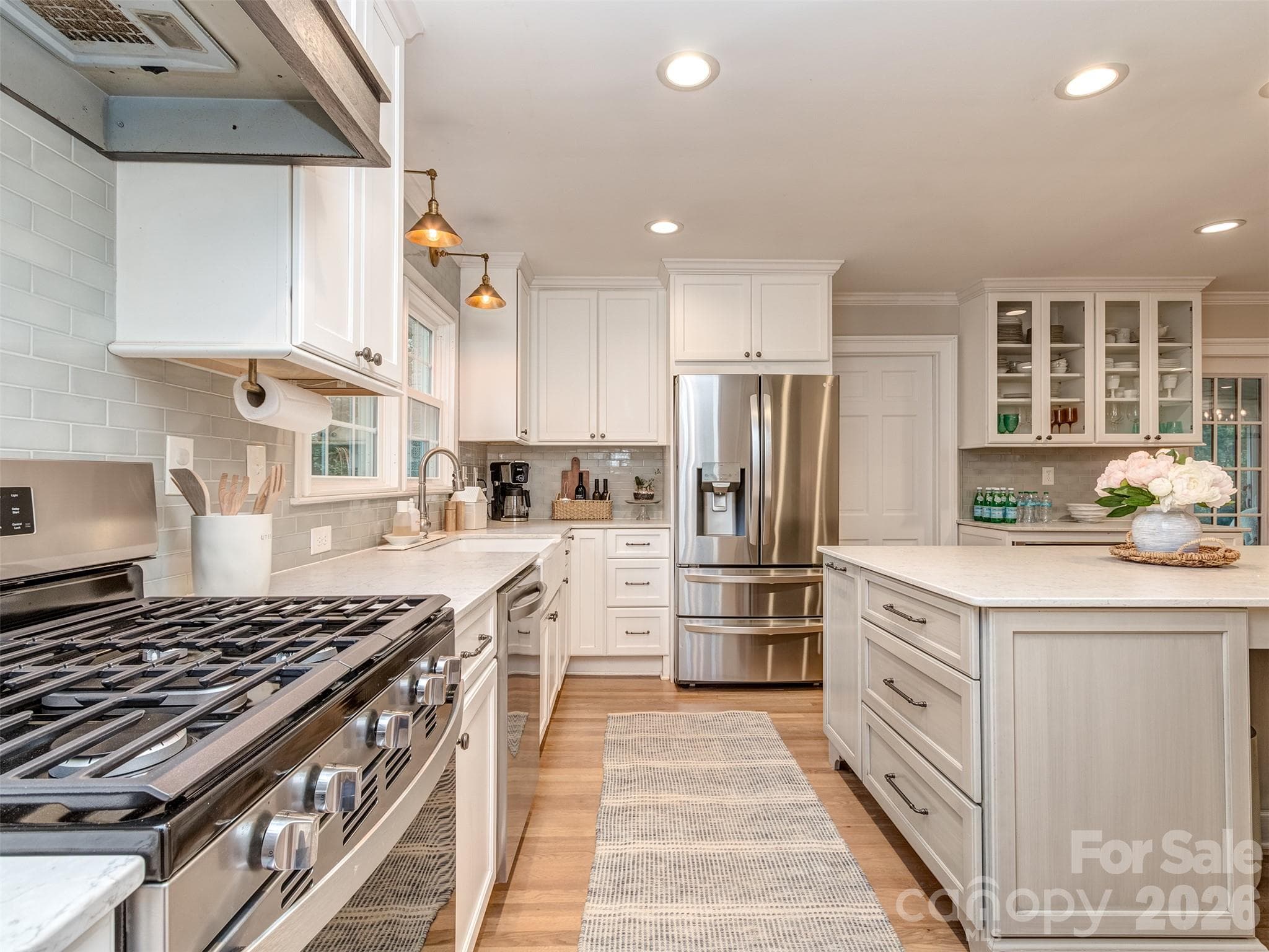 The gourmet kitchen is spectacular with updated stainless appliances, oversized island with seating area, custom cabinets & drawers, gas range, built-in shelving, pantry cabinet & more! - 6129 Page Court, Charlotte