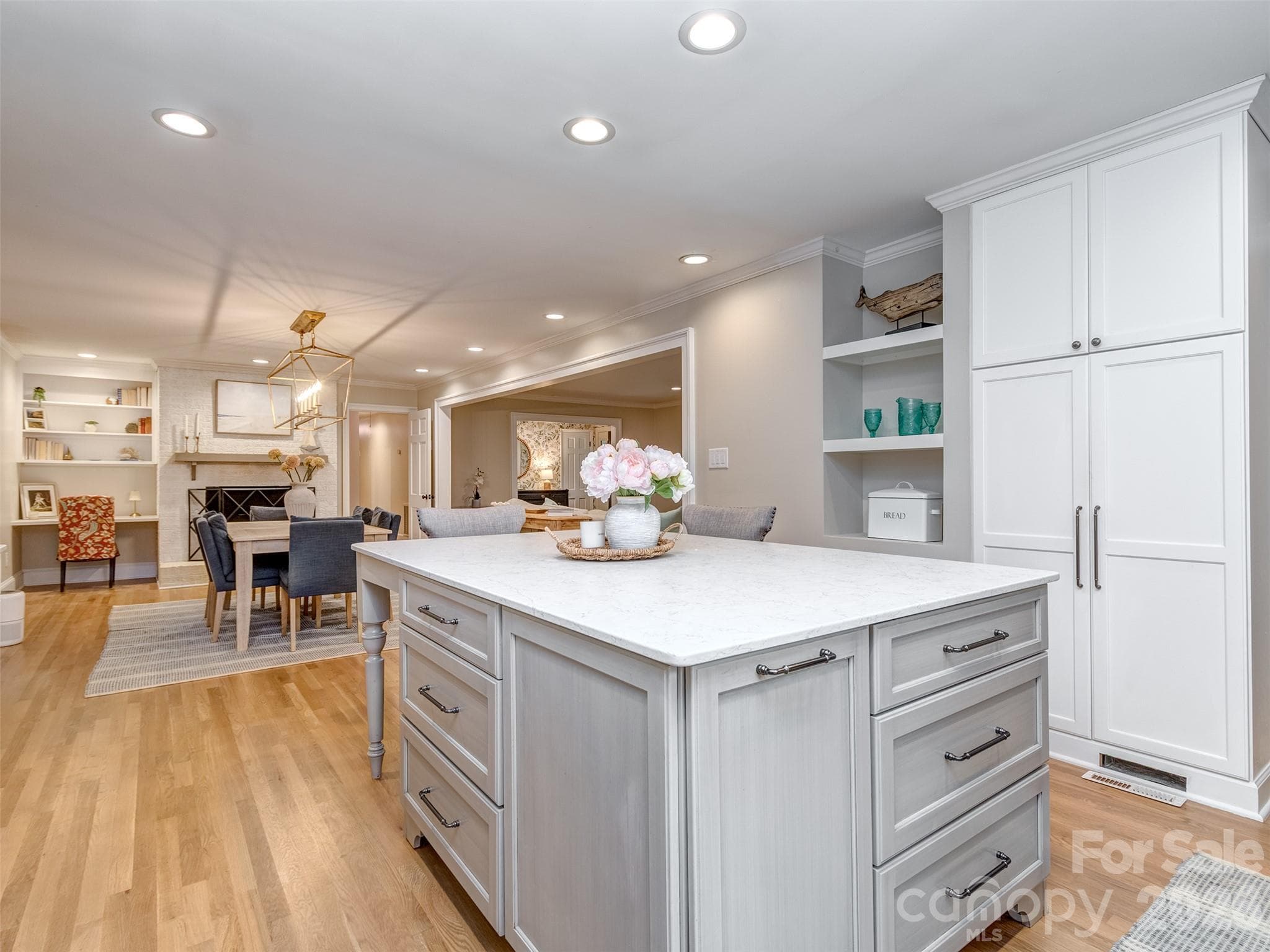 The gourmet kitchen is spectacular with updated stainless appliances, oversized island with seating area, custom cabinets & drawers, gas range, built-in shelving, pantry cabinet & more! - 6129 Page Court, Charlotte