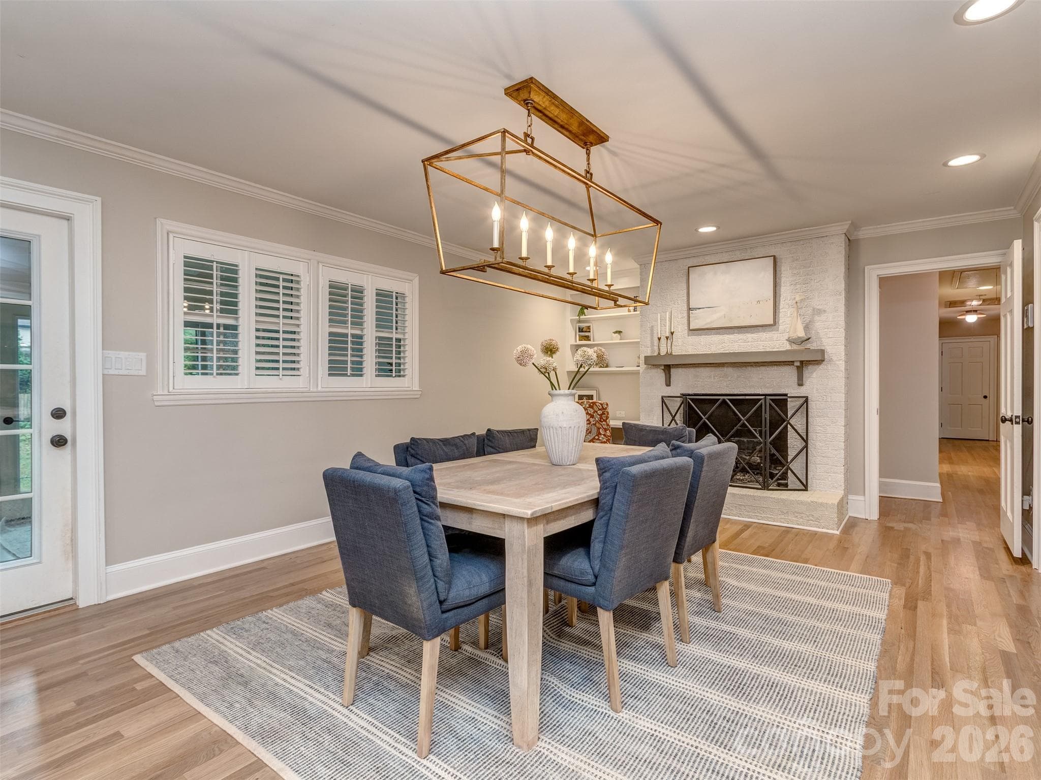 The formal dining room has custom light fixture, gas log fireplace, site finished hardwood flooring, & is perfectly situated between the kitchen, great room, & screened porch! - 6129 Page Court, Charlotte