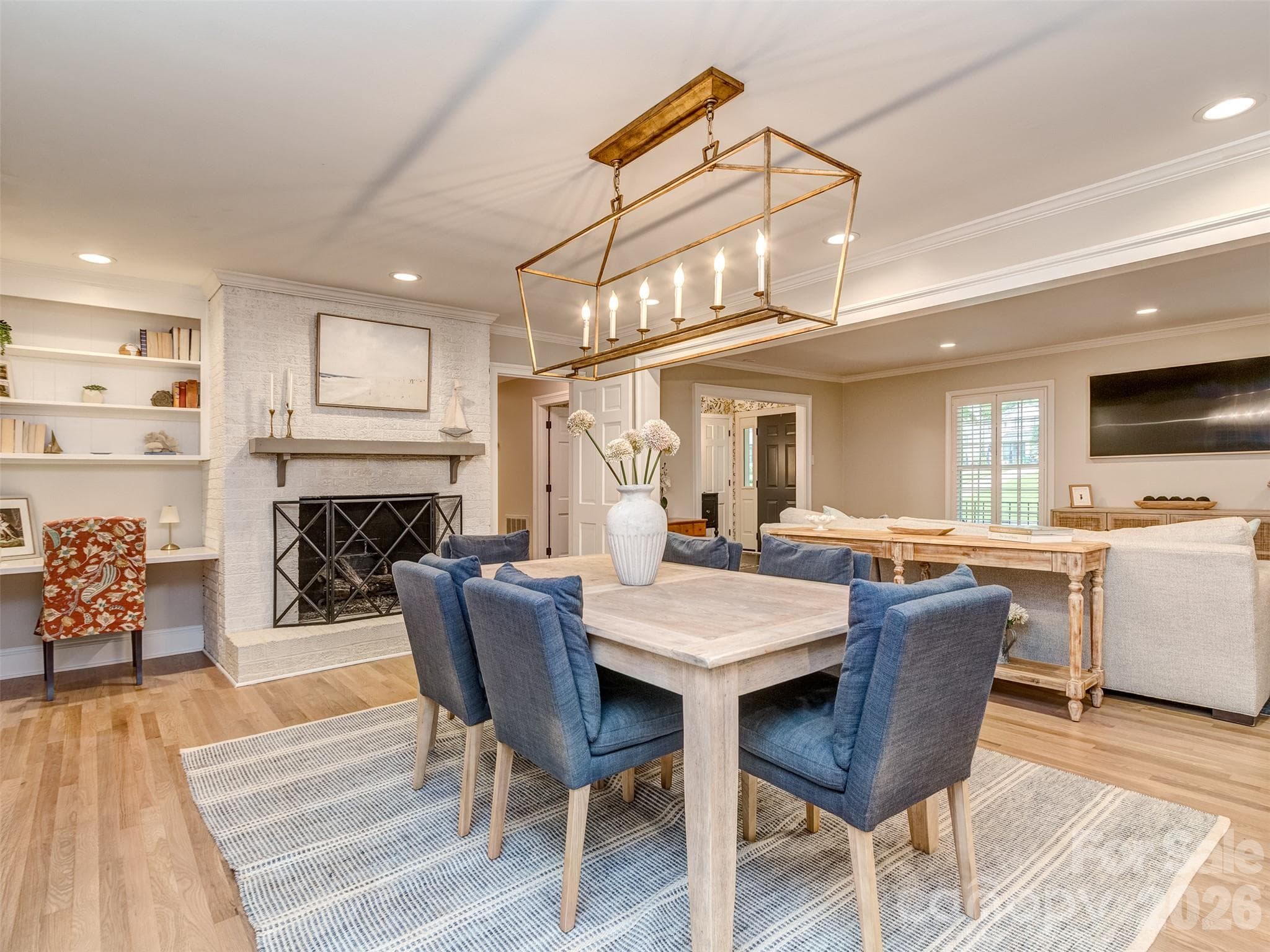 The formal dining room has custom light fixture, gas log fireplace, site finished hardwood flooring, & is perfectly situated between the kitchen, great room, & screened porch! - 6129 Page Court, Charlotte