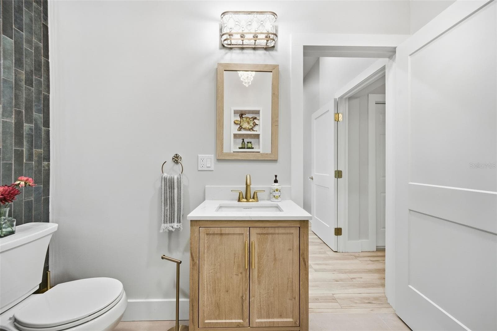 Light-wood vanity Brass fixtures and statement crystal lighting - 5837 TENNESSEE AVE, NEW PORT RICHEY