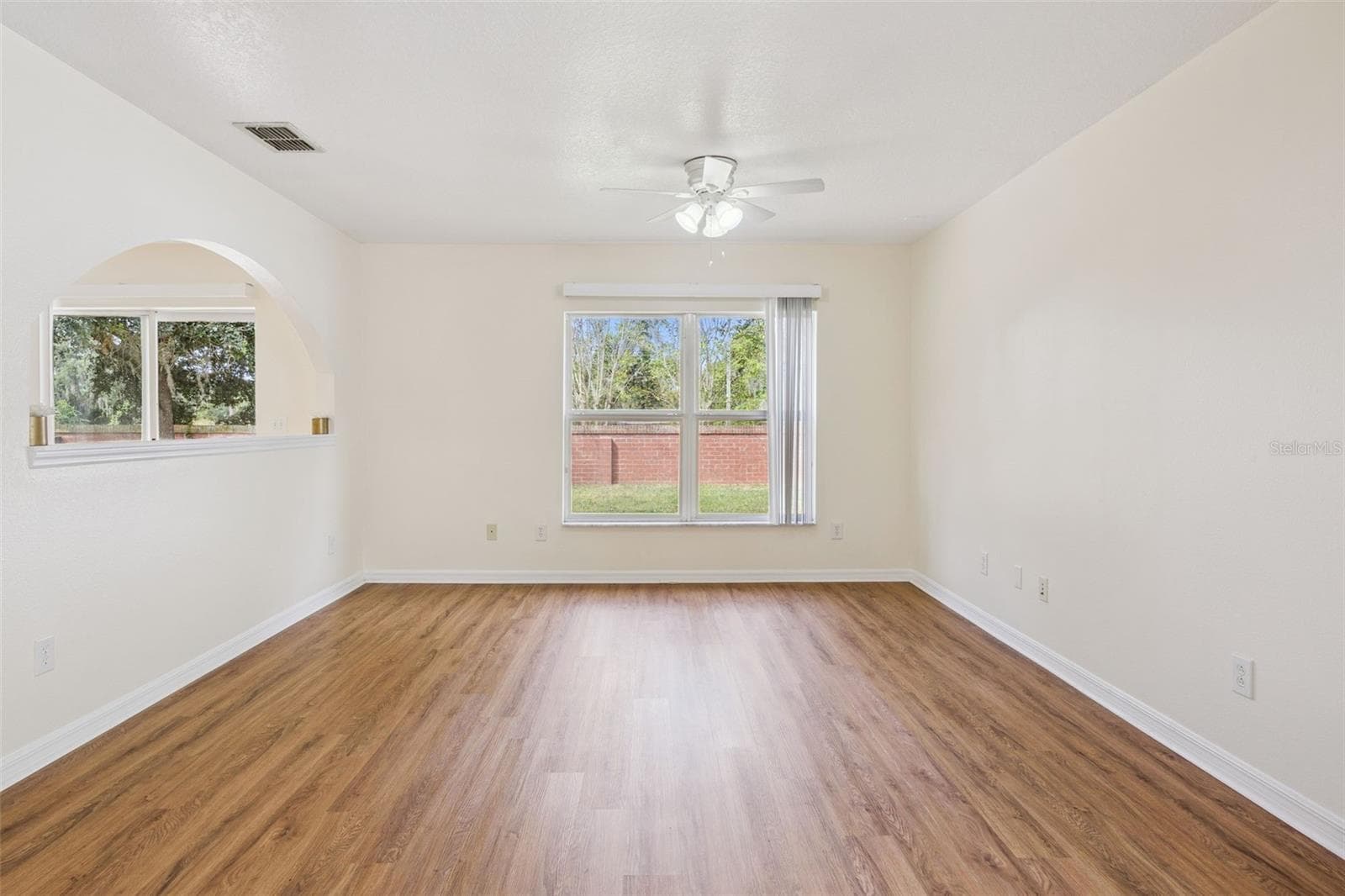 Family room (12'10" x 14'3") with new LVP flooring and arched pass-through to the breakfast nook - 2020 PORTCASTLE CIR, WINTER GARDEN