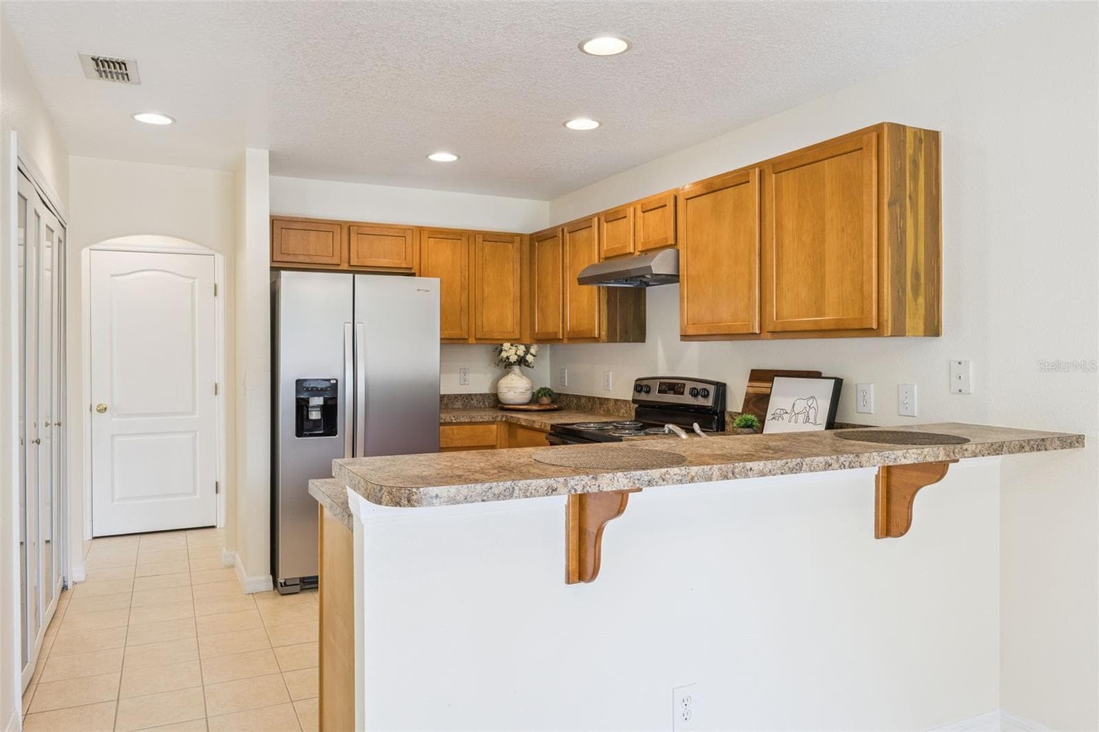Kitchen with breakfast bar and stainless steel appliances - 2020 PORTCASTLE CIR, WINTER GARDEN