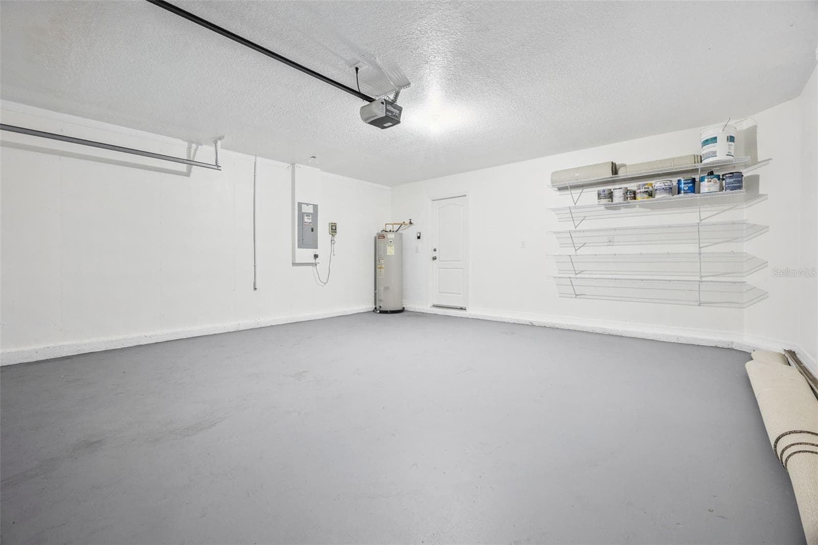 Two-car garage (18'8" x 19'6") with freshly painted floor and new wire storage - 2020 PORTCASTLE CIR, WINTER GARDEN