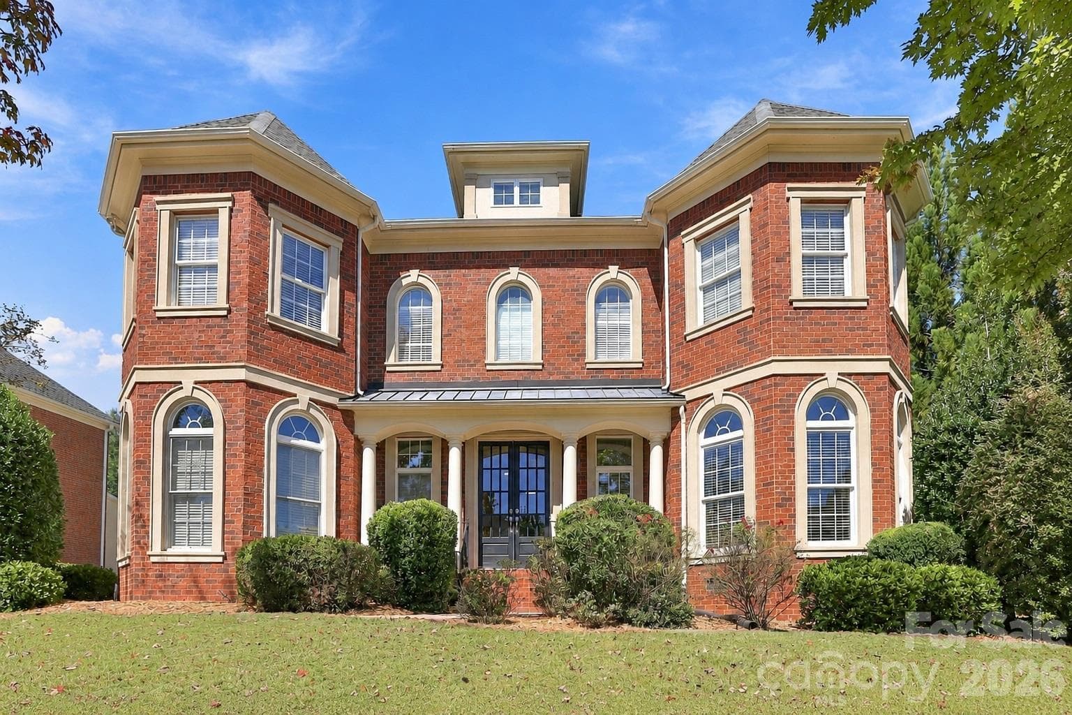 Beautifully balanced and undeniably impressive, this expansive façade hints at the 5,400+ square feet and three finished levels waiting inside. - 2309 Highland Forest Drive, Waxhaw