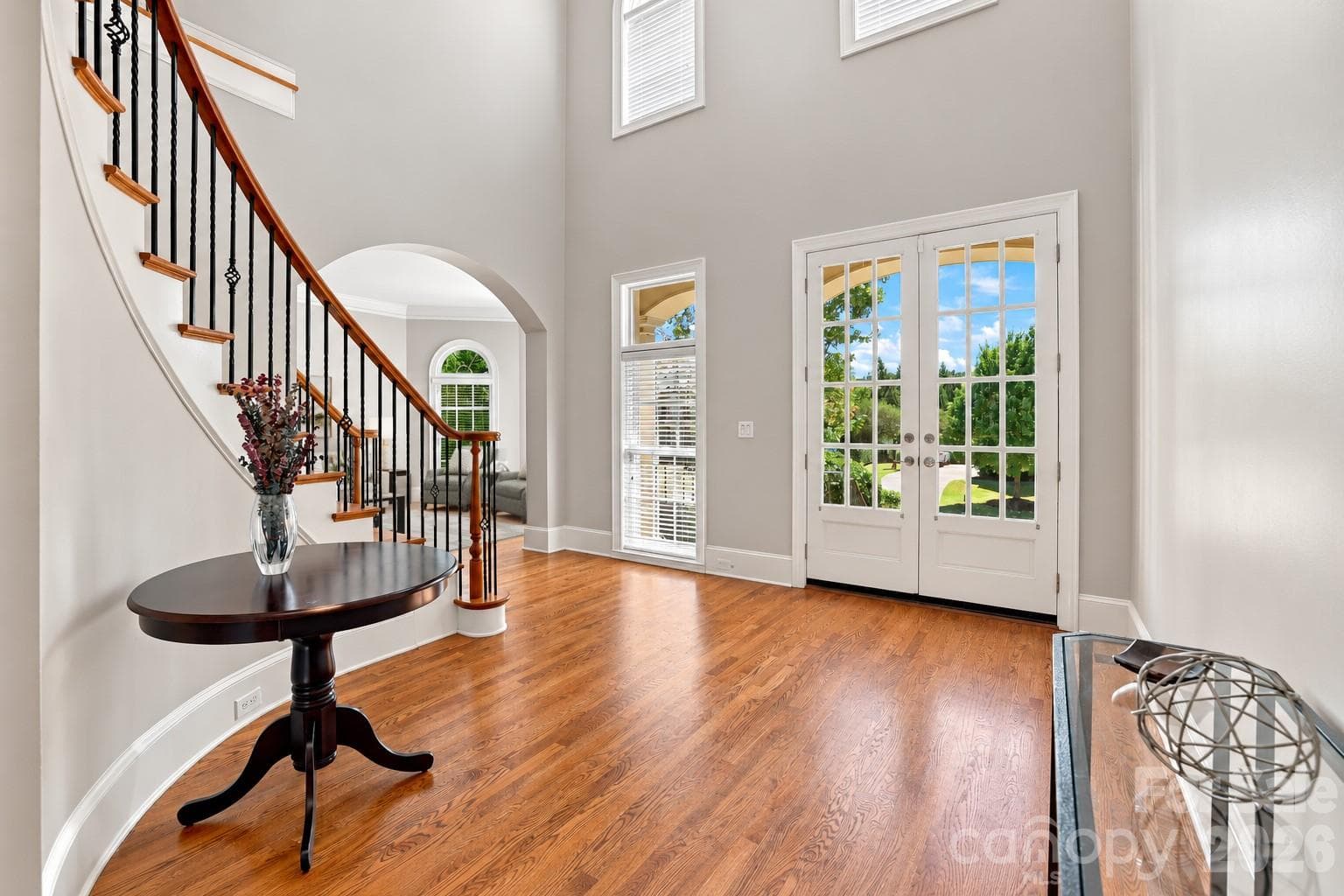 A stunning entrance! Double glass doors open to a spacious two-story foyer filled with natural light, with the curved staircase providing a memorable first impression. - 2309 Highland Forest Drive, Waxhaw