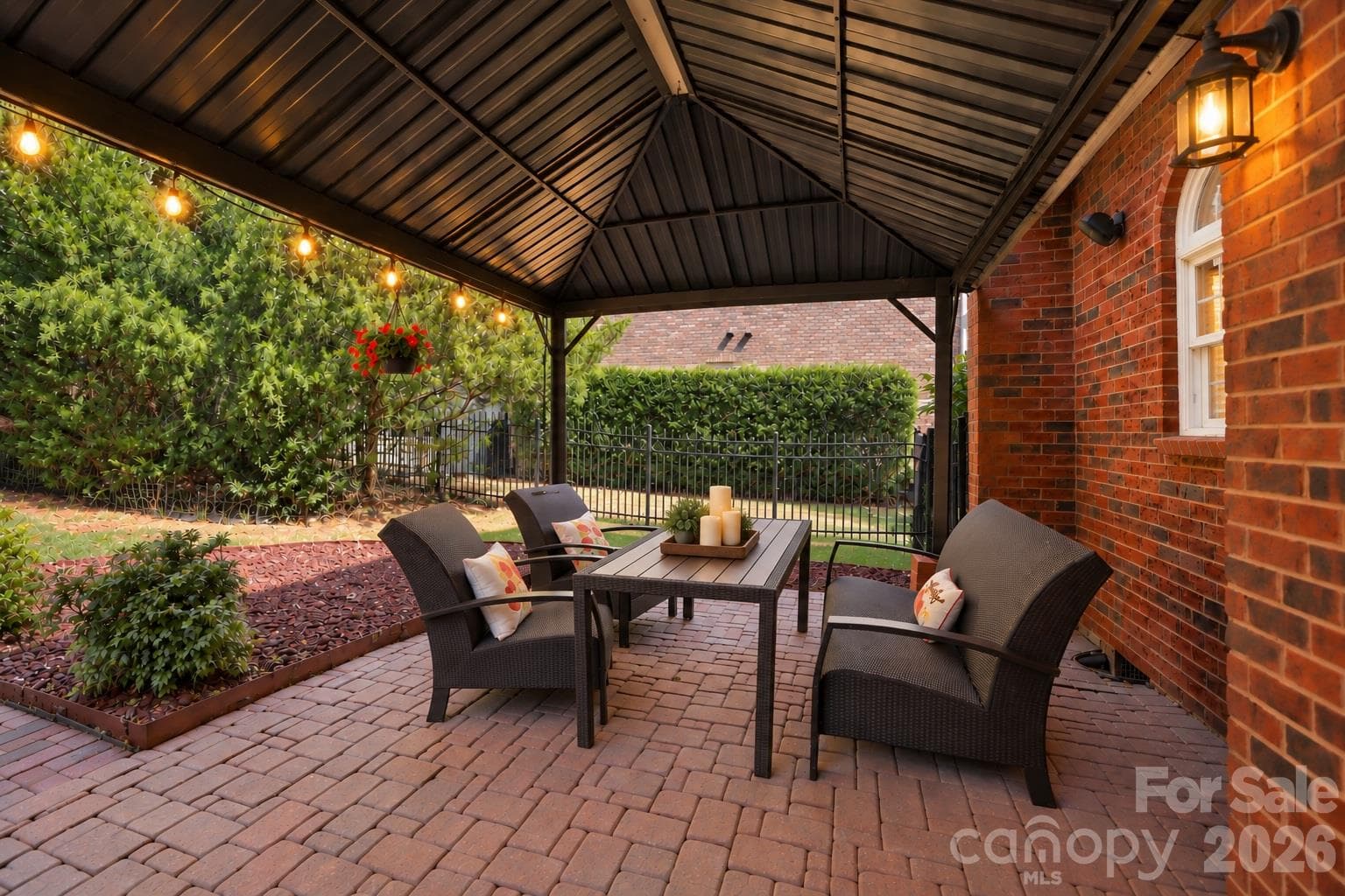 The covered brick paver patio is  a natural extension of the home’s living and entertaining areas, creating a wonderful setting for al fresco dining, weekend brunches or dinner with friends. With plenty of room for a full dining table and chairs, it’s a space that makes outdoor dining and entertaining an easy part of everyday life. - 2309 Highland Forest Drive, Waxhaw