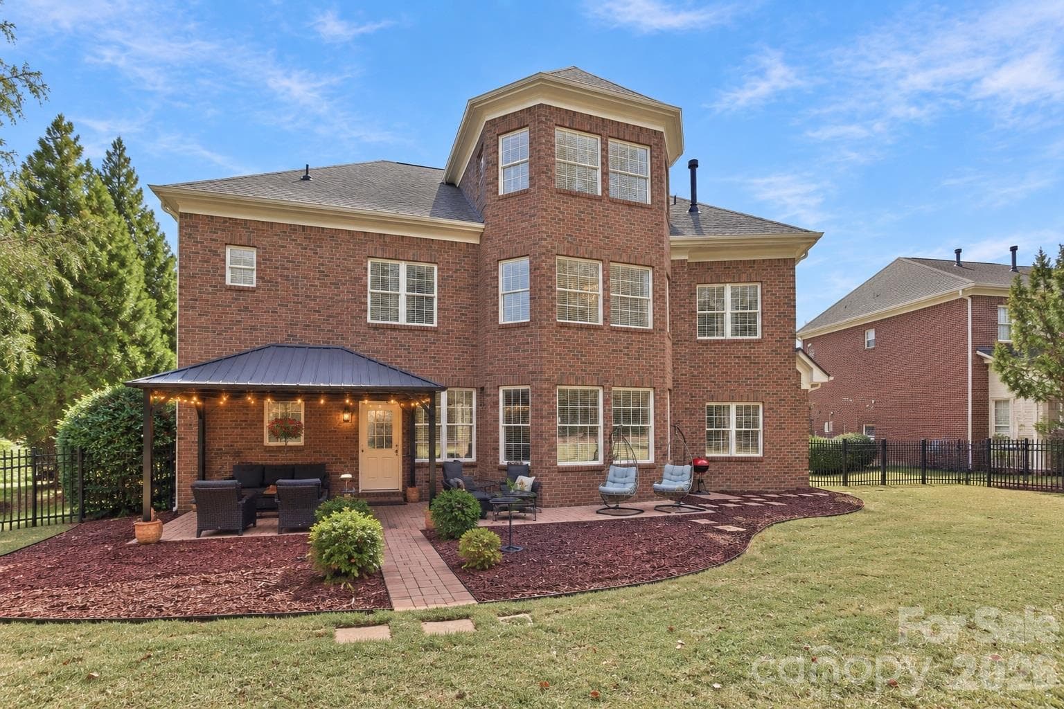 The view from the backyard shows another side of this impressive home, with its three-story design, curved rear architecture and multiple sets of windows creating a striking exterior. It’s a beautiful backdrop to all the time you’ll want to spend outside. - 2309 Highland Forest Drive, Waxhaw