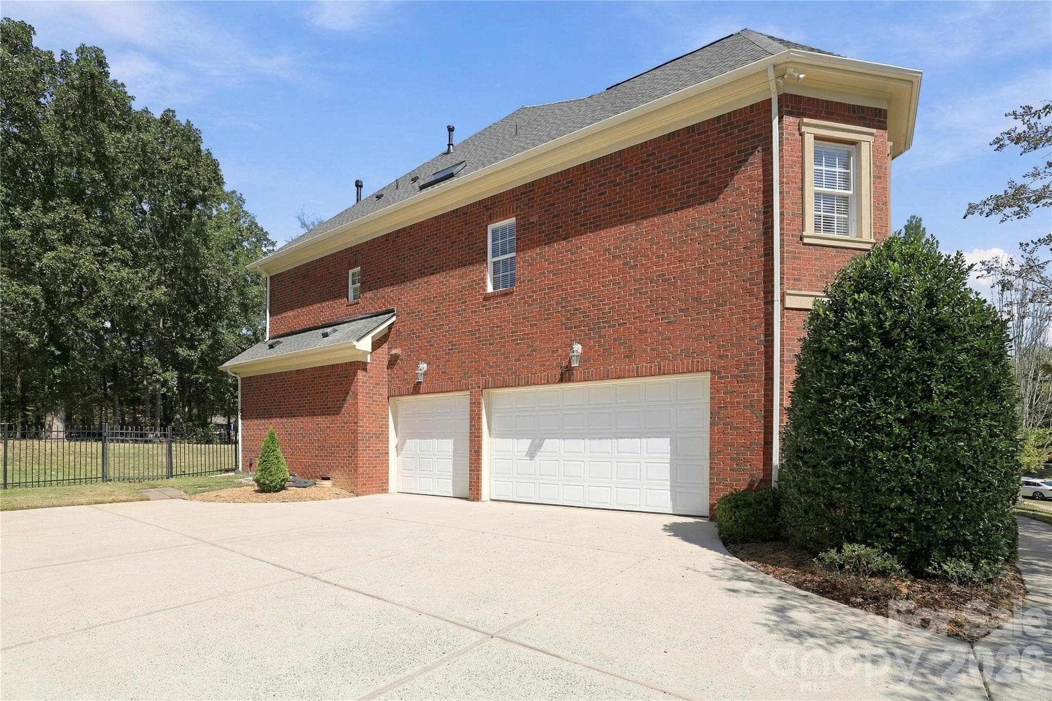 A three-car side-load garage is a major plus, providing room for multiple vehicles along with additional space for bikes, lawn equipment or other storage. The wide driveway offers plenty of room for additional parking and easy maneuvering.  The side-load design allows the home’s architecture and landscaping to take center stage from the street. - 2309 Highland Forest Drive, Waxhaw
